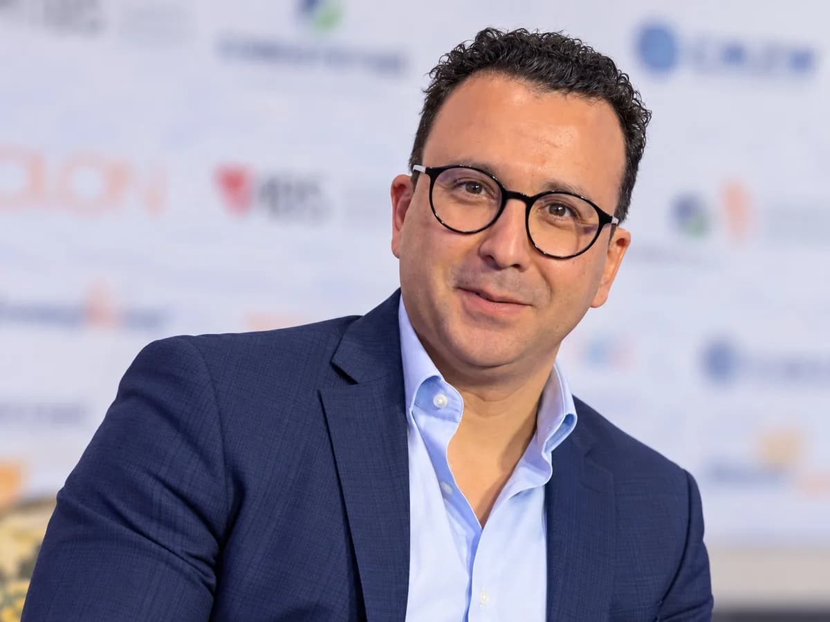 Portrait de Redouane Zemama, souriant, en veste bleu marine et chemise bleu ciel